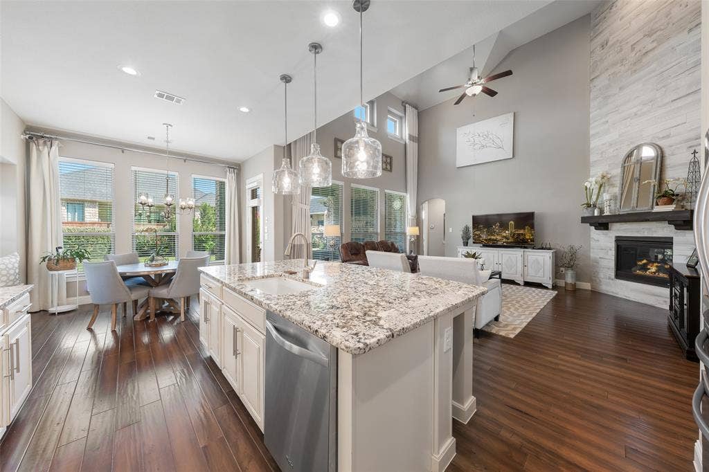 121 Lantana Lane, Wylie, TX 75098 Open-concept living space with wood-finish flooring, a kitchen island with granite countertops, and white cabinetry