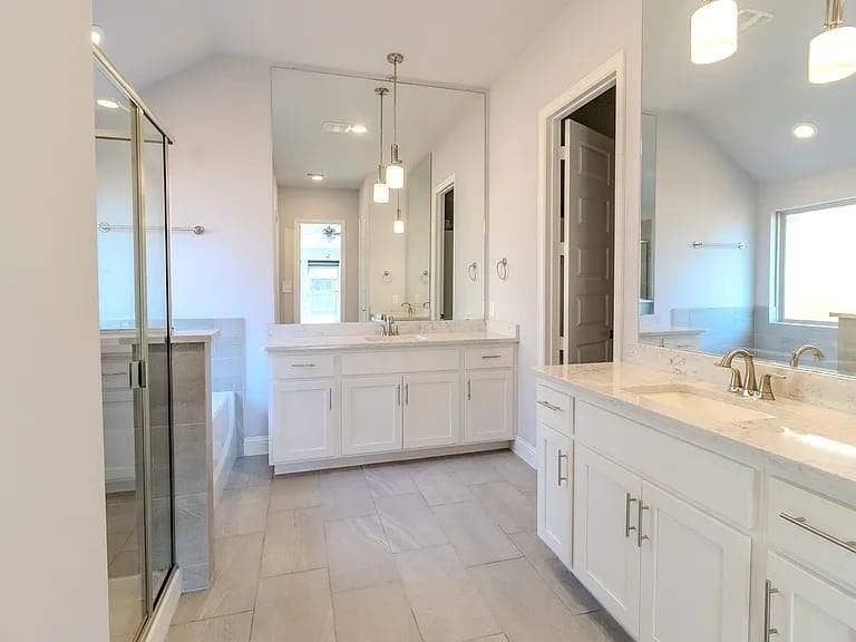Dual vanity with undermount sinks, white cabinetry, and light-toned countertops