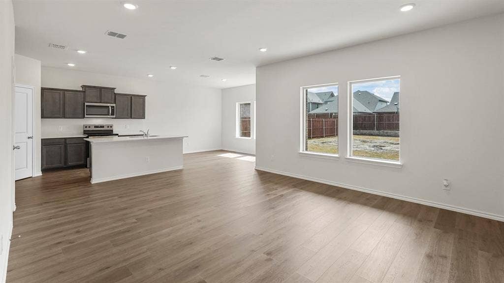 5610 Gannet Place, Crandall, TX 75114 Open-concept living space featuring wood-finish flooring, recessed lighting, and white walls