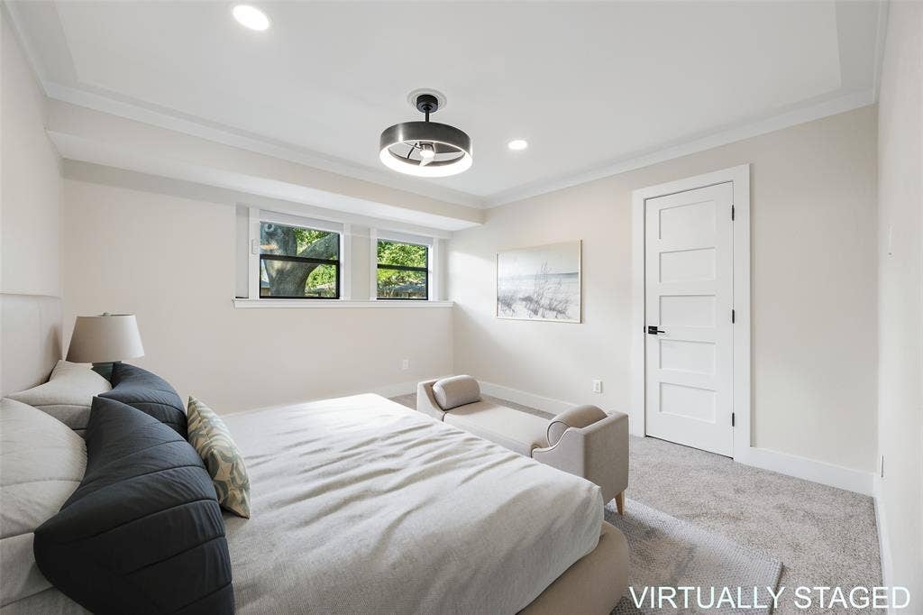 Guest bedroom featuring neutral finishes, abundant natural light, a modern ceiling fan, fresh carpet and generous closet space.