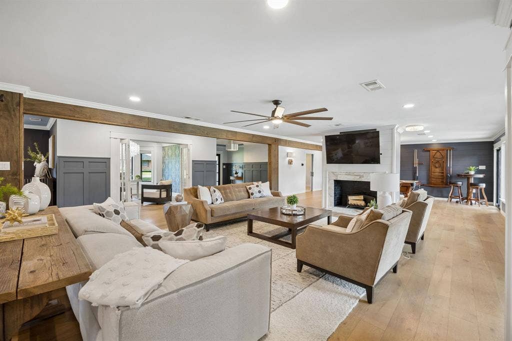 Additional view of the spacious living area highlighting the open layout, wood floors and seamless connection to the kitchen and adjoining entertaining spaces.