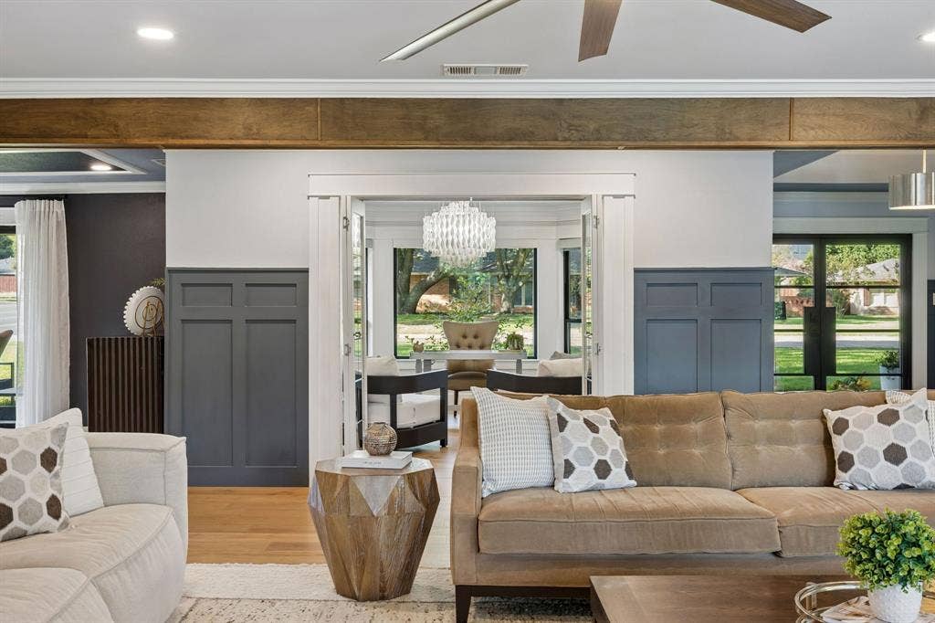 View from the living room showcasing decorative wainscoting, wood floors and French doors opening to the beautifully appointed home office.