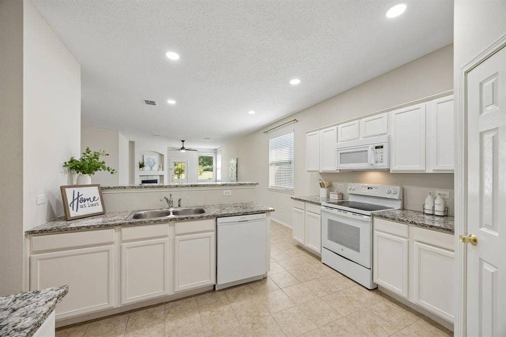 Cooking Without Missing What’s Happening – The open kitchen keeps the family room and casual dining area within view, making it easy to prepare meals while staying connected to conversation, guests, or the golf course views beyond.