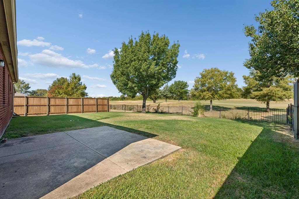 A Backyard Built Around the Setting – The rear of the home opens to a spacious fenced yard with patio access, while the golf course frontage beyond gives the outdoor space a sense of openness that is hard to replicate.