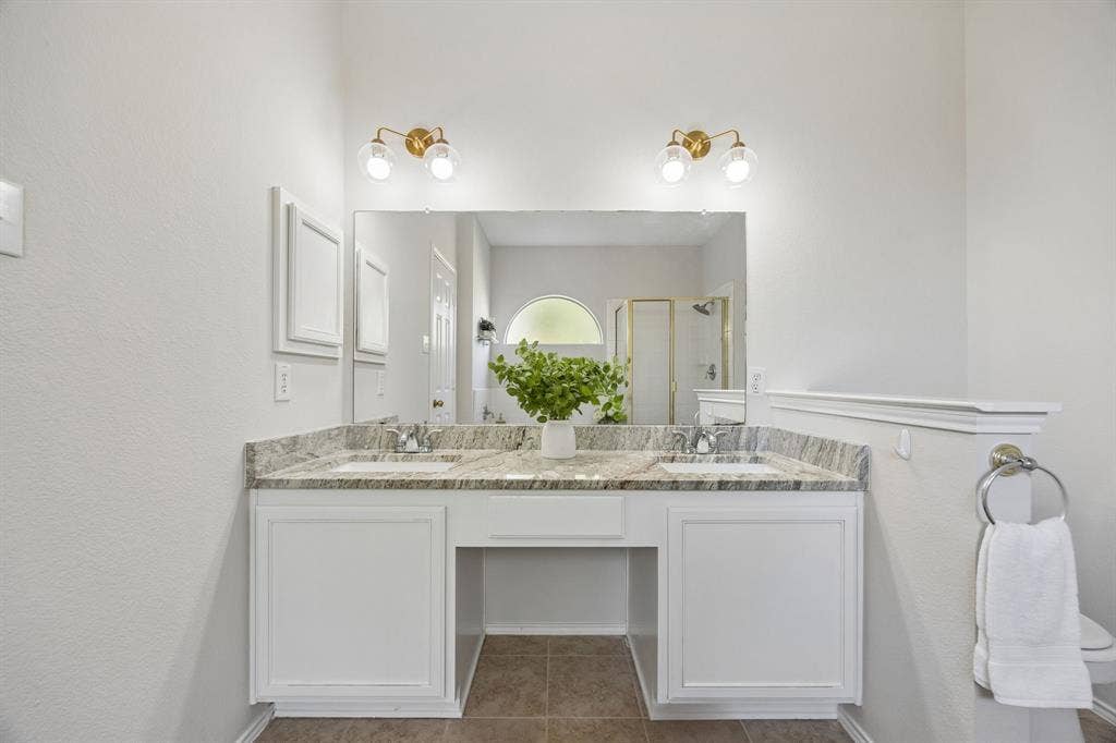 A Primary Bath with Room to Share – A wide dual-sink vanity with a granite top, updated fixtures, and generous counter space creates a functional setup for busy mornings and everyday routines.