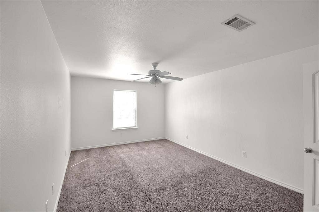 1102 Parkway Trail, Princeton, TX 75407 White painted walls, neutral carpet, single window, white ceiling fan, and white paneled door