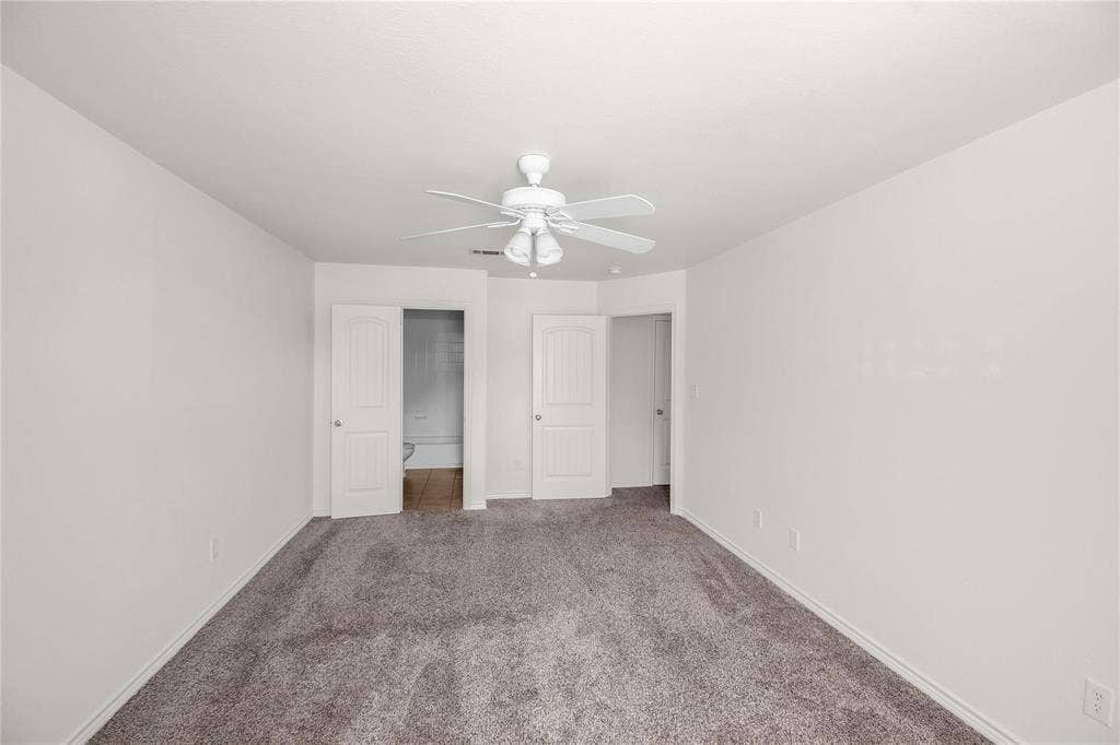 1102 Parkway Trail, Princeton, TX 75407 Spacious room featuring neutral carpeting, a ceiling fan with light fixture, and two panel doors