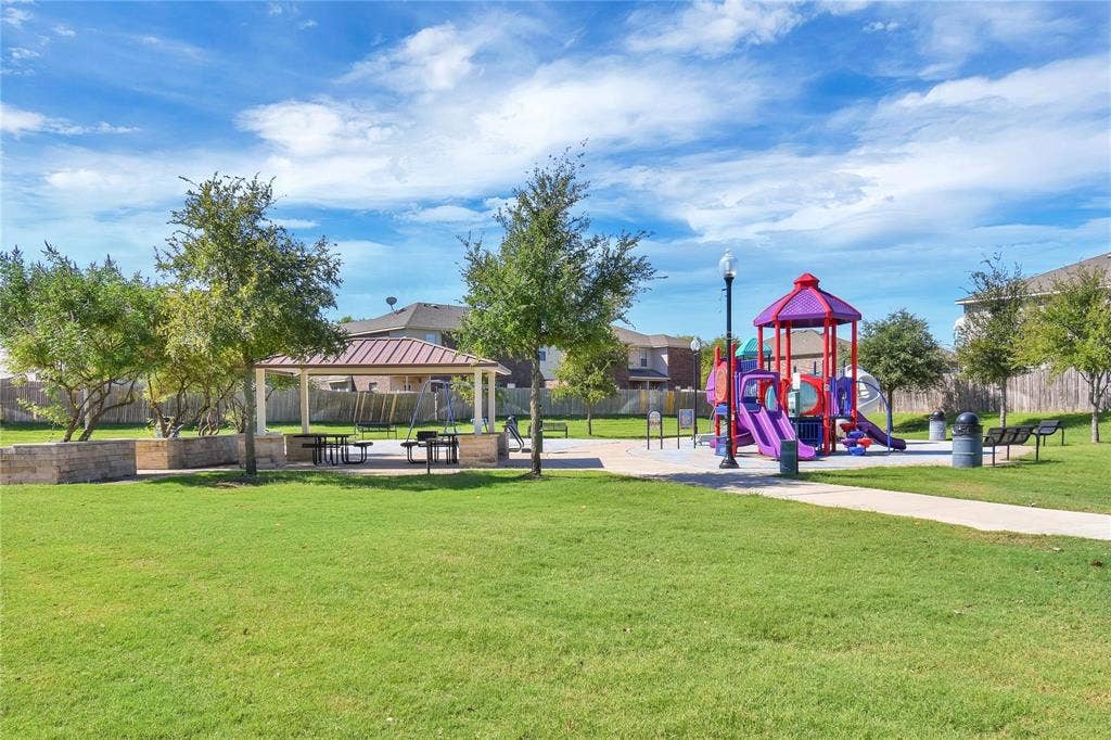 1102 Parkway Trail, Princeton, TX 75407 Community playground featuring multiple slides and climbing elements, a covered picnic area with seating, and a paved pathway