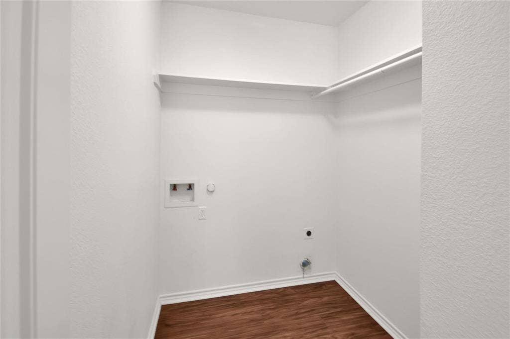 1102 Parkway Trail, Princeton, TX 75407 Utility closet with wood-finish flooring, white baseboards, and built-in shelving