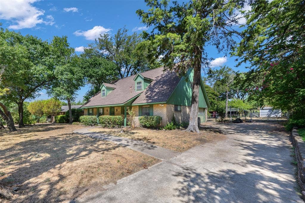 635 Sherrill Boulevard, Duncanville, TX 75116 Brick and wood siding exterior with a shingle roof and dormer windows