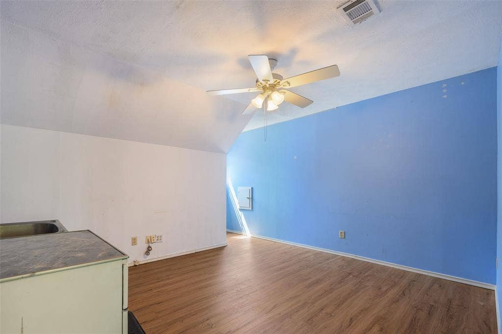 635 Sherrill Boulevard, Duncanville, TX 75116 Sloped ceiling with an integrated ceiling fan, wood-finish flooring, and a compact utility sink