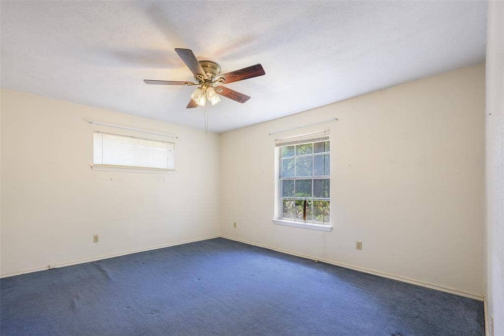 635 Sherrill Boulevard, Duncanville, TX 75116 Blue carpeting with a window and a ceiling fan
