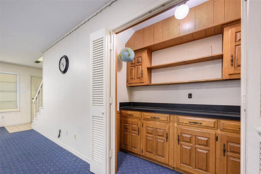 635 Sherrill Boulevard, Duncanville, TX 75116 Built-in cabinetry with wood-finish doors and hardware, dark countertops, and open shelving