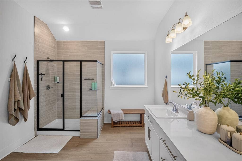 Walk-in shower with tiled walls and a built-in bench