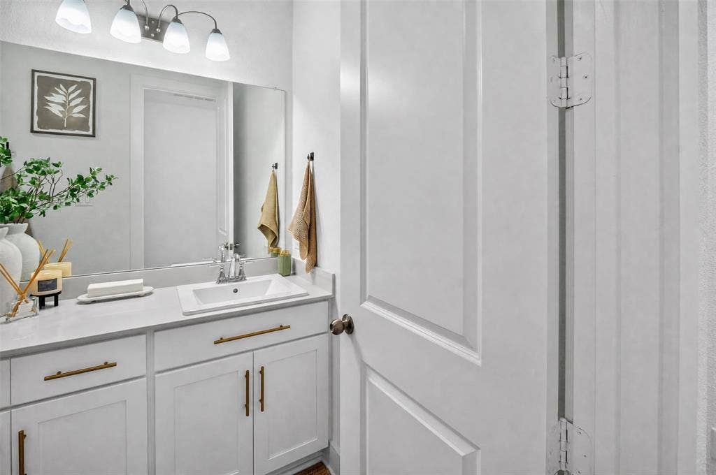 Spacious vanity with undermount sink, brass hardware, and a large wall-mounted mirror