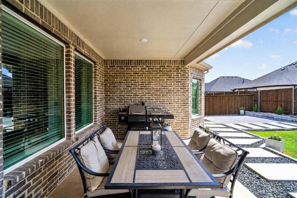 Covered patio featuring brick exterior walls and recessed lighting