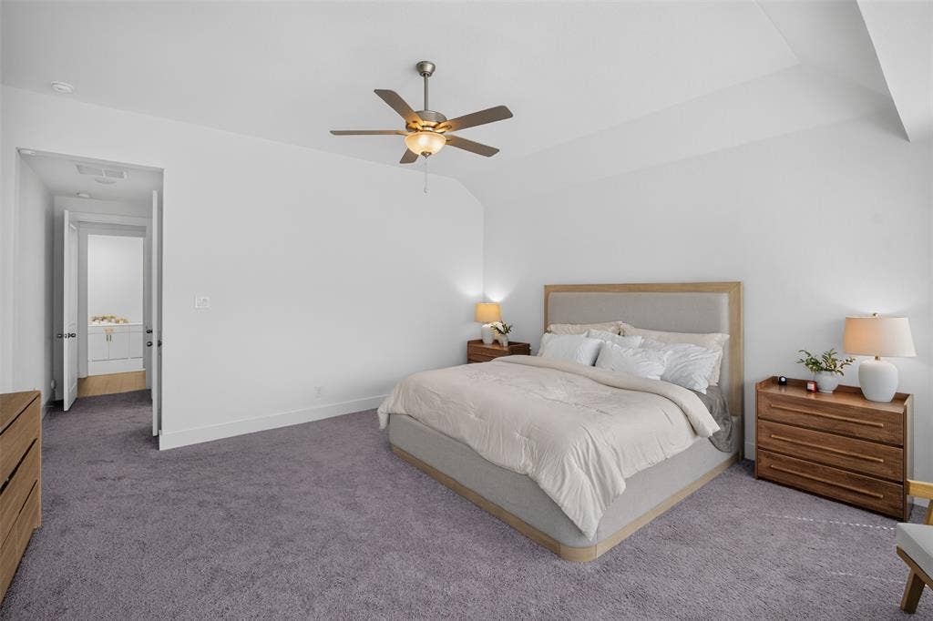 Tray ceiling with a ceiling fan, light gray carpeting, and a white wall finish