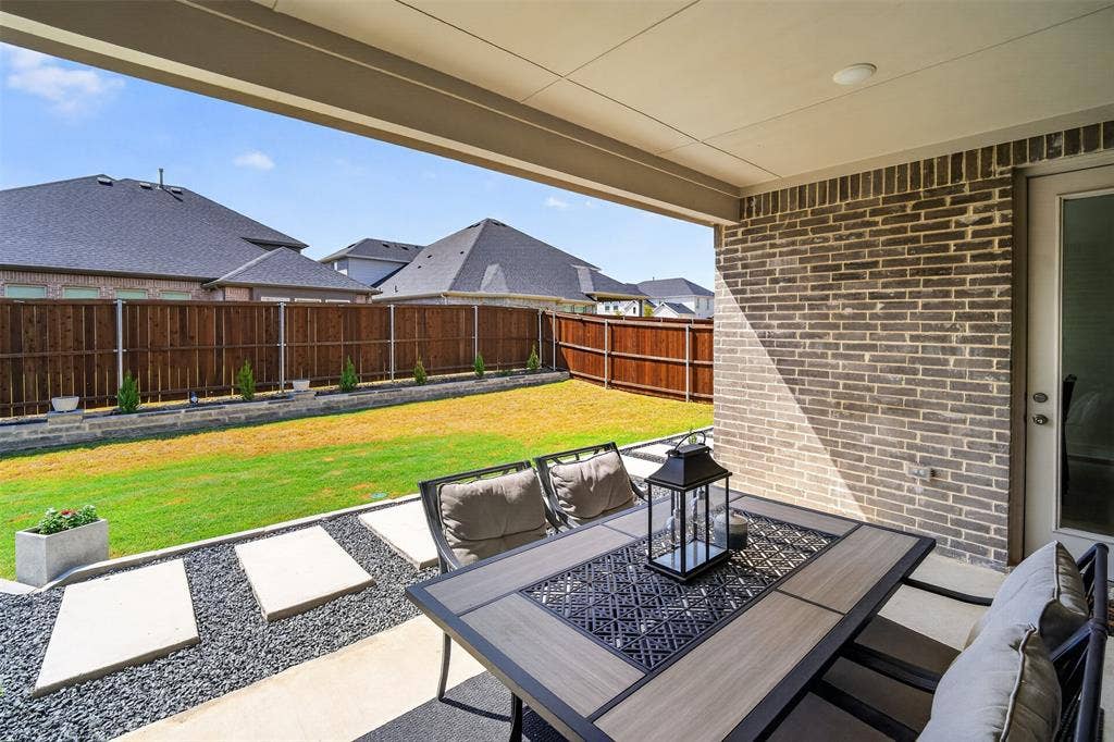 Covered patio with brick exterior, concrete flooring, and recessed lighting