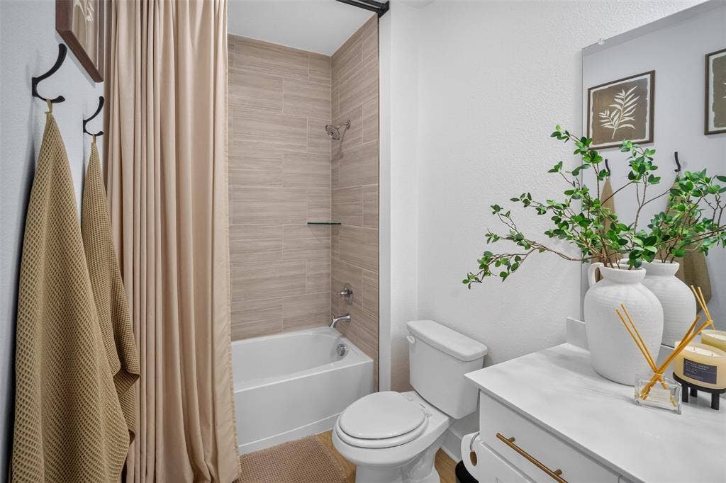 Tub/shower combination with subway tile surround, wall-mounted showerhead, and glass shelf