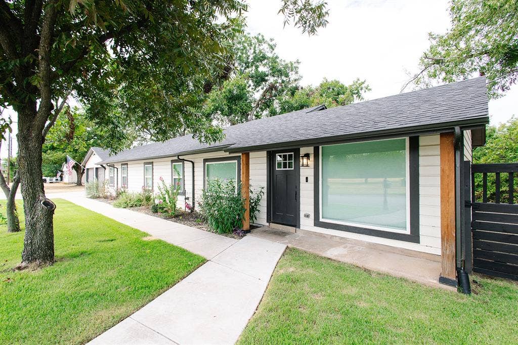 104 S Hawthorne Street, Granbury, TX 76048 White horizontal siding with dark trim accents
