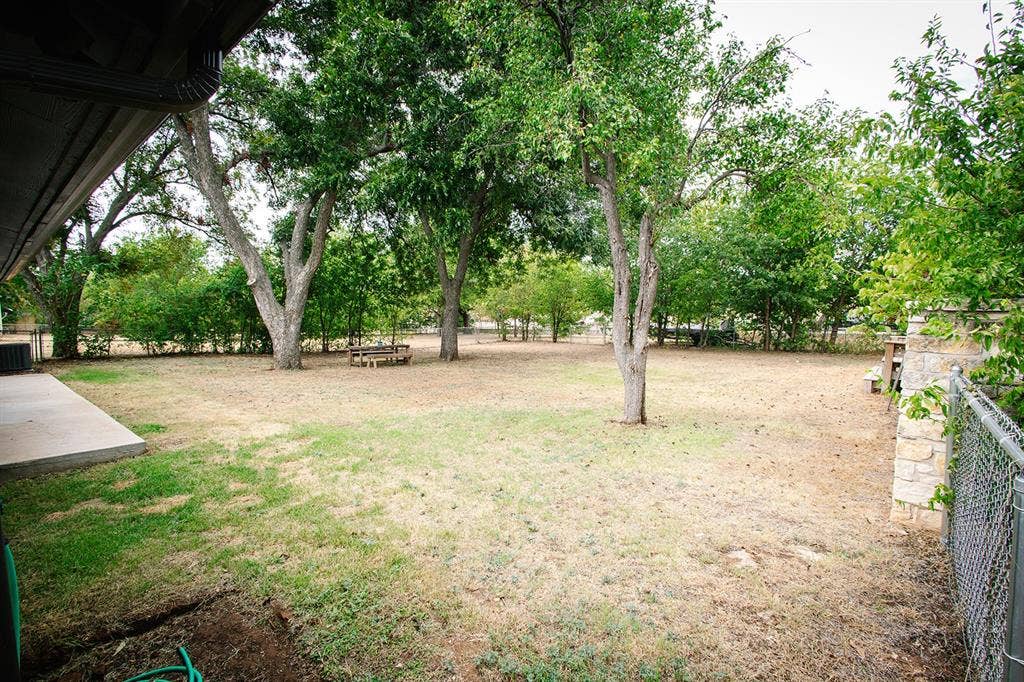 104 S Hawthorne Street, Granbury, TX 76048 Expansive yard space featuring mature trees and a concrete patio