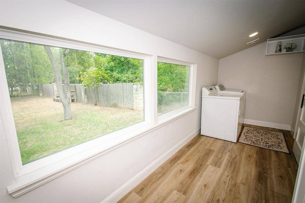 104 S Hawthorne Street, Granbury, TX 76048 Separate fenced area Expansive backyard featuring a mature tree, chain-link fencing, and a dark slat fence
