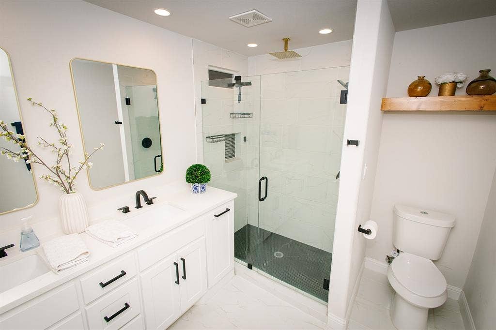 104 S Hawthorne Street, Granbury, TX 76048 Dual sink vanity with white cabinetry and matte black hardware