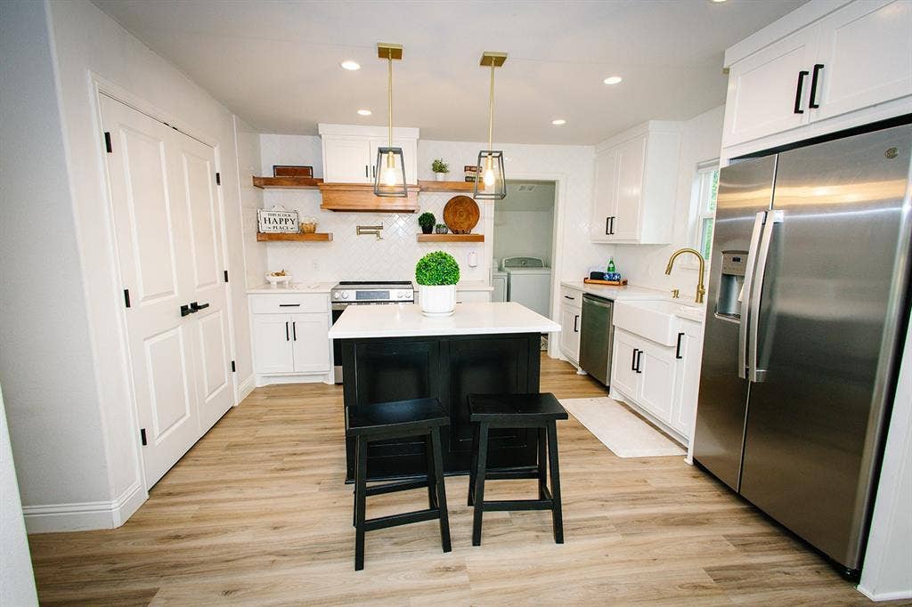 104 S Hawthorne Street, Granbury, TX 76048 Kitchen featuring wood-finish flooring, white cabinetry, a central island with countertop, stainless steel appliances, and open shelving