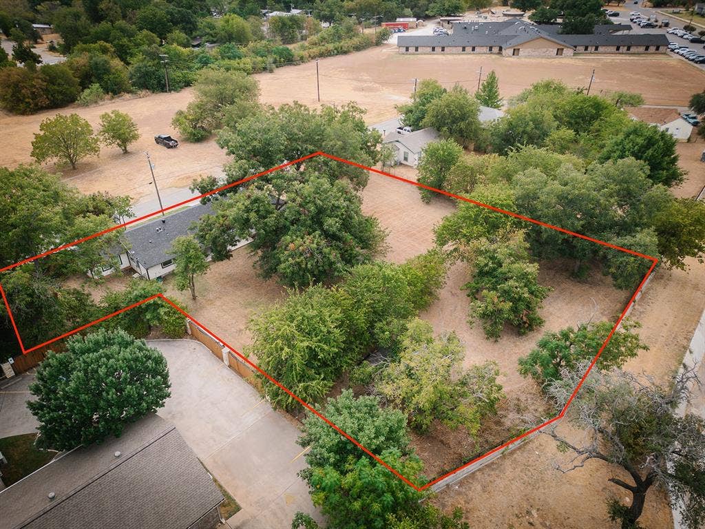 104 S Hawthorne Street, Granbury, TX 76048 Expansive property featuring mature trees, a defined boundary, and a paved driveway