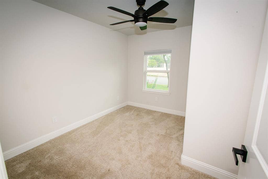 104 S Hawthorne Street, Granbury, TX 76048 Neutral wall paint, carpeted flooring, window with exterior exposure, and ceiling fan with lighting