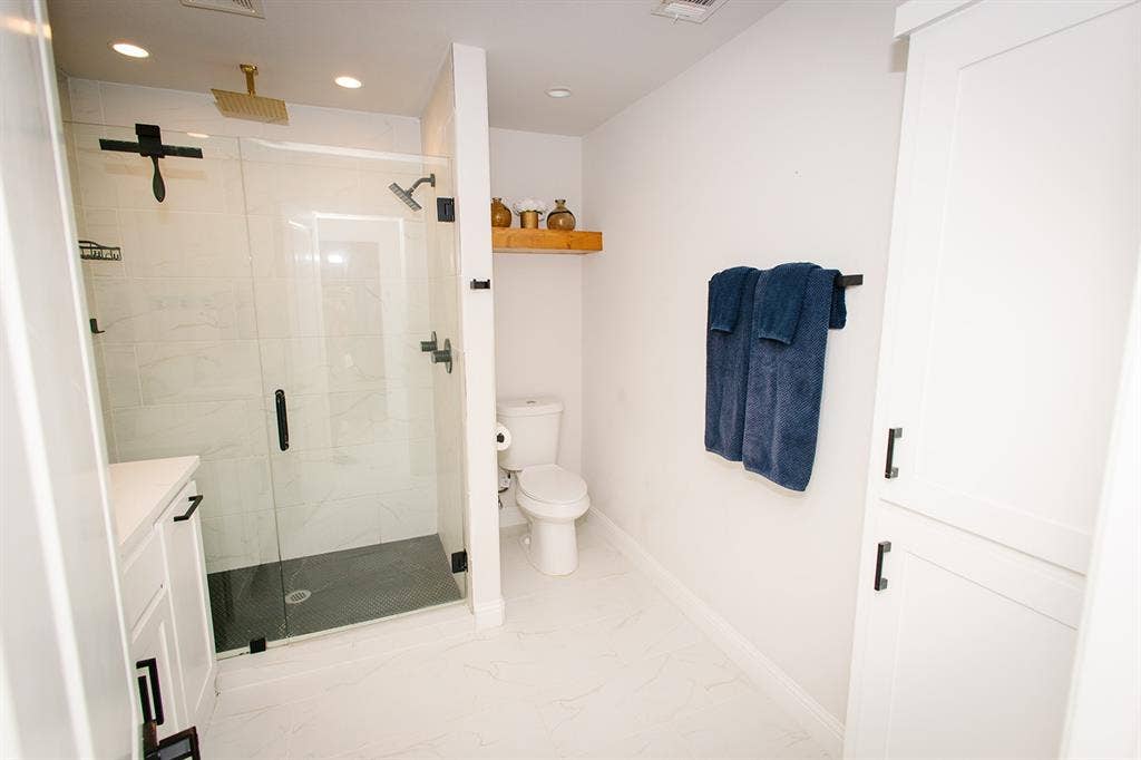 104 S Hawthorne Street, Granbury, TX 76048 Master bath Glass-enclosed shower with black fixtures and a gold-toned rain showerhead