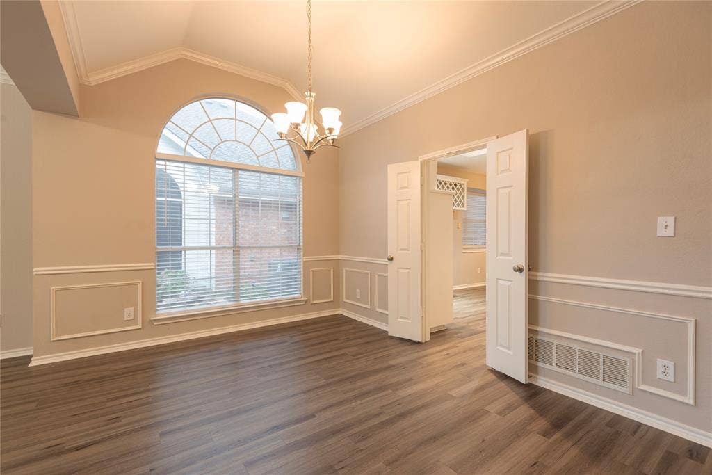 7829 Case Drive, Plano, TX 75025 Unfurnished dining area with dark hardwood / wood-style flooring, ornamental molding, and vaulted ceiling