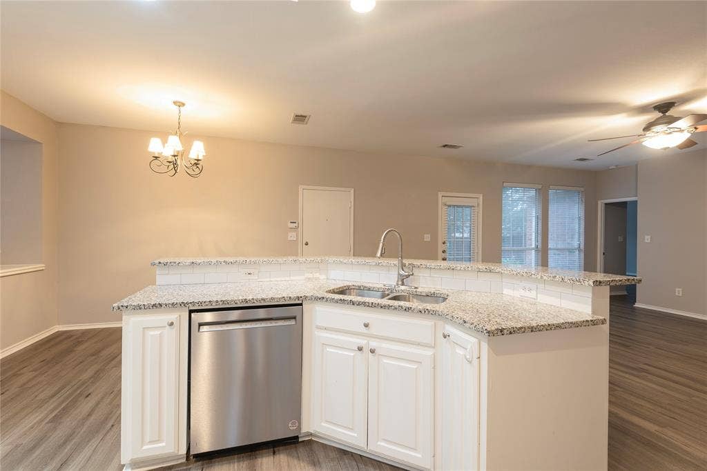 7829 Case Drive, Plano, TX 75025 Kitchen with stainless steel dishwasher, a kitchen island with sink, sink, decorative light fixtures, and white cabinets