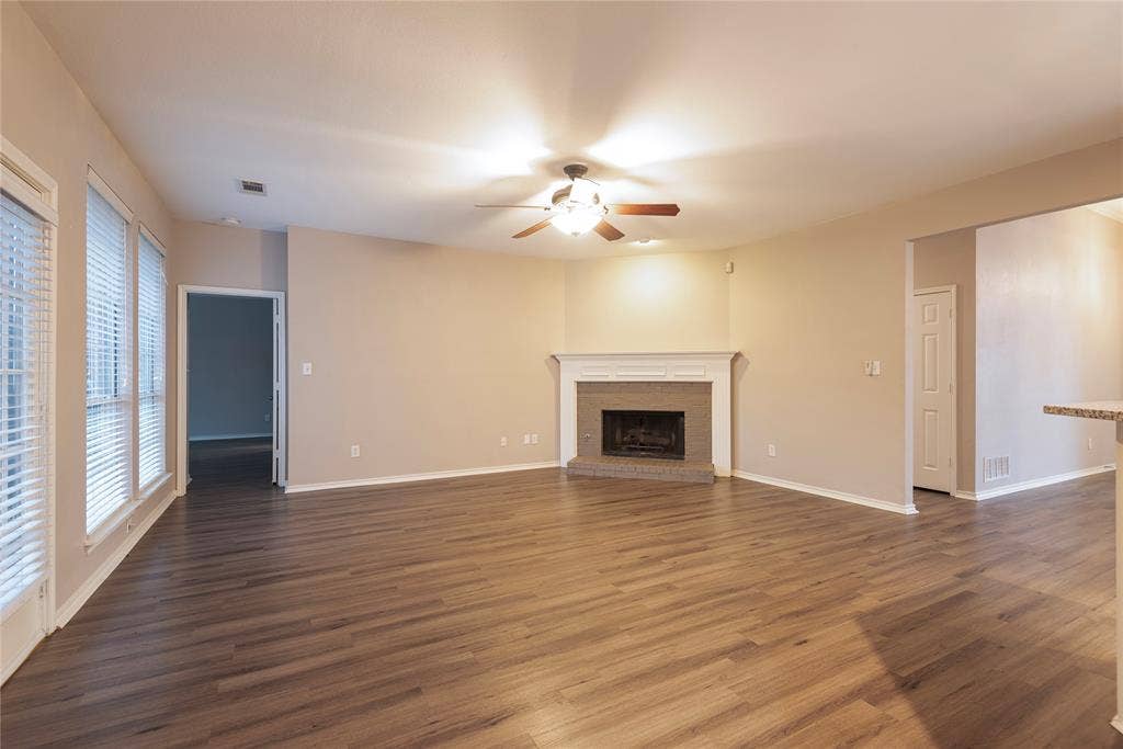 7829 Case Drive, Plano, TX 75025 Unfurnished living room with dark hardwood / wood-style floors, ceiling fan, and a brick fireplace