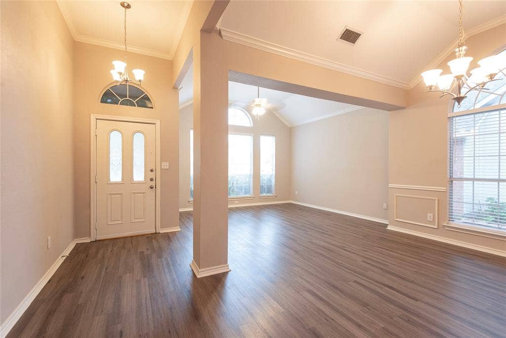 7829 Case Drive, Plano, TX 75025 Entryway featuring ceiling fan with notable chandelier, crown molding, and dark wood-type flooring