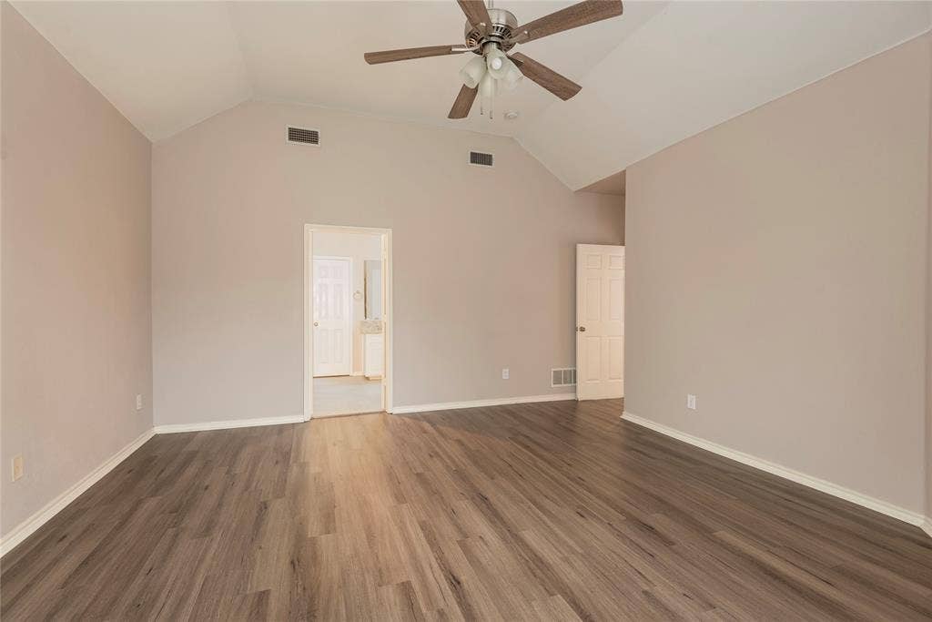 7829 Case Drive, Plano, TX 75025 Empty room featuring ceiling fan, dark hardwood / wood-style flooring, and vaulted ceiling