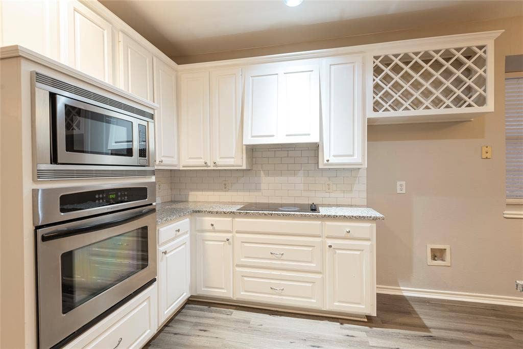 7829 Case Drive, Plano, TX 75025 Kitchen featuring white cabinetry, light wood-type flooring, stainless steel appliances, and tasteful backsplash