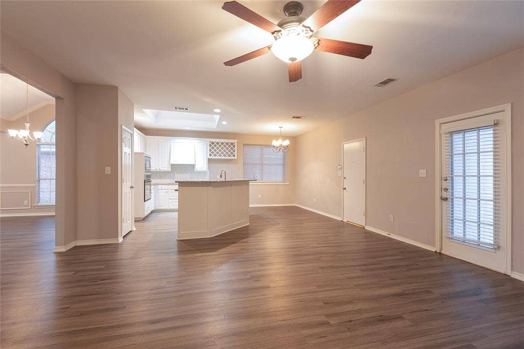 7829 Case Drive, Plano, TX 75025 Kitchen featuring a skylight, a kitchen island, decorative light fixtures, dark hardwood / wood-style floors, and white cabinetry