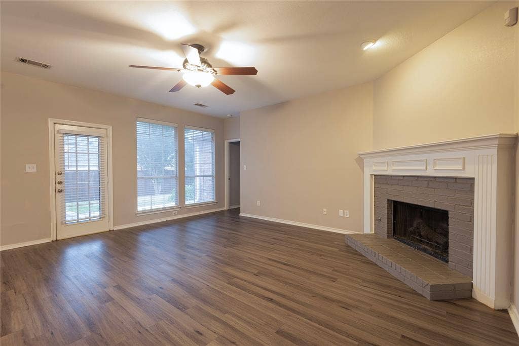 7829 Case Drive, Plano, TX 75025 Unfurnished living room with dark hardwood / wood-style floors, ceiling fan, and a brick fireplace