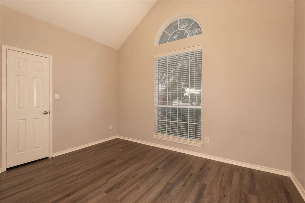 7829 Case Drive, Plano, TX 75025 Spare room with dark hardwood / wood-style floors and high vaulted ceiling