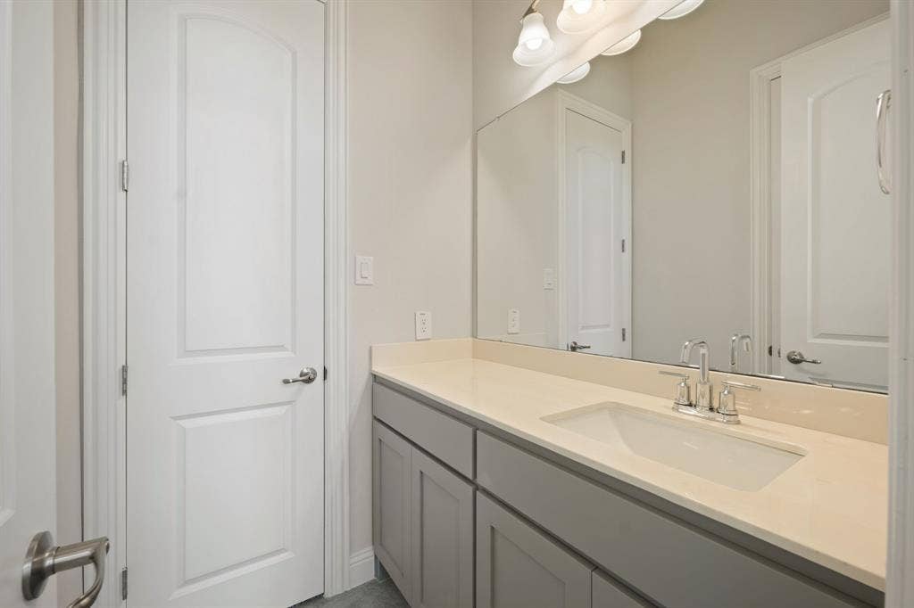 Vanity featuring a light-toned countertop, undermount sink, and chrome faucet