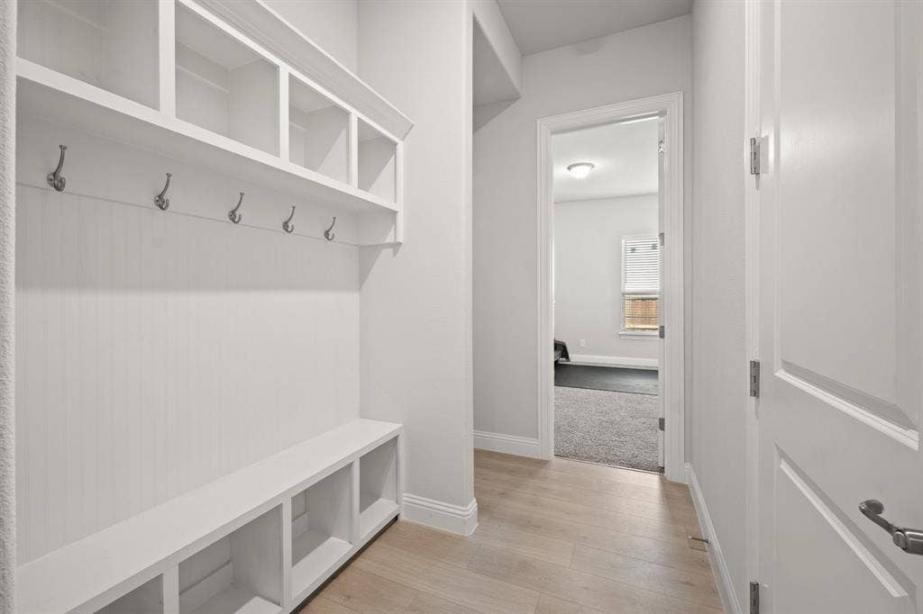 Built-in storage bench with cubbies, upper shelving, and coat hooks