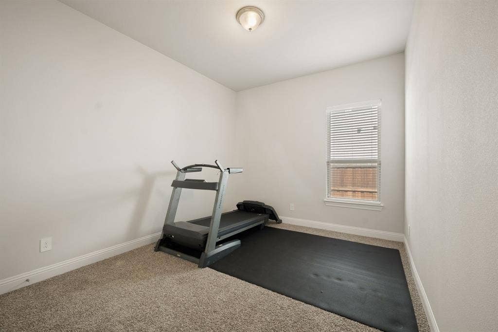 Carpeted room with a single window, white window blinds, and a flush mount ceiling light