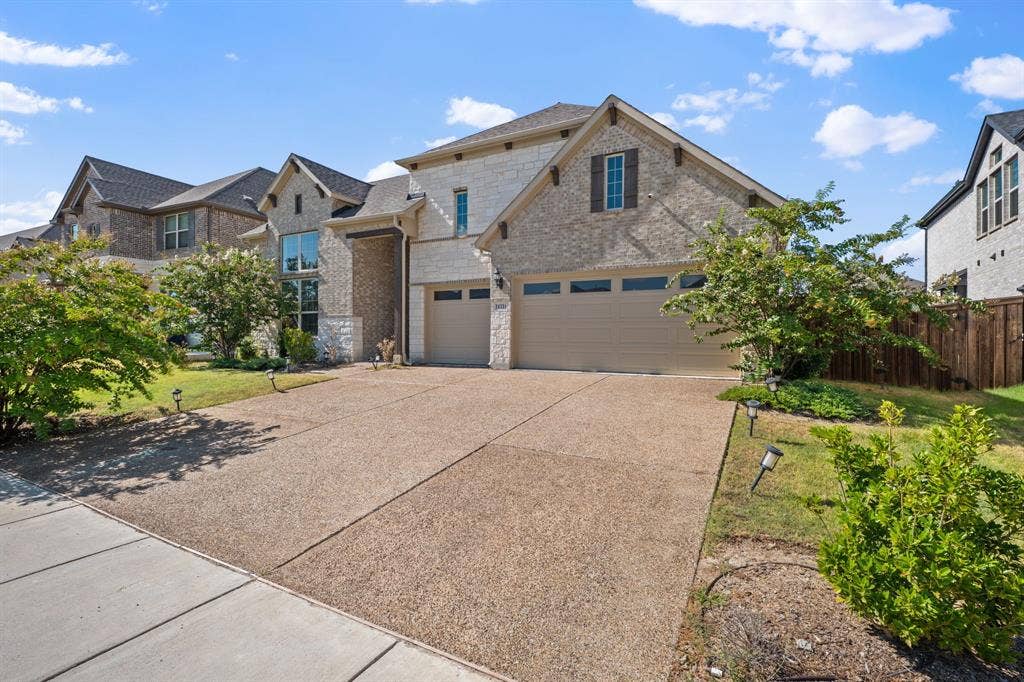 Stone and brick exterior with a three-car garage