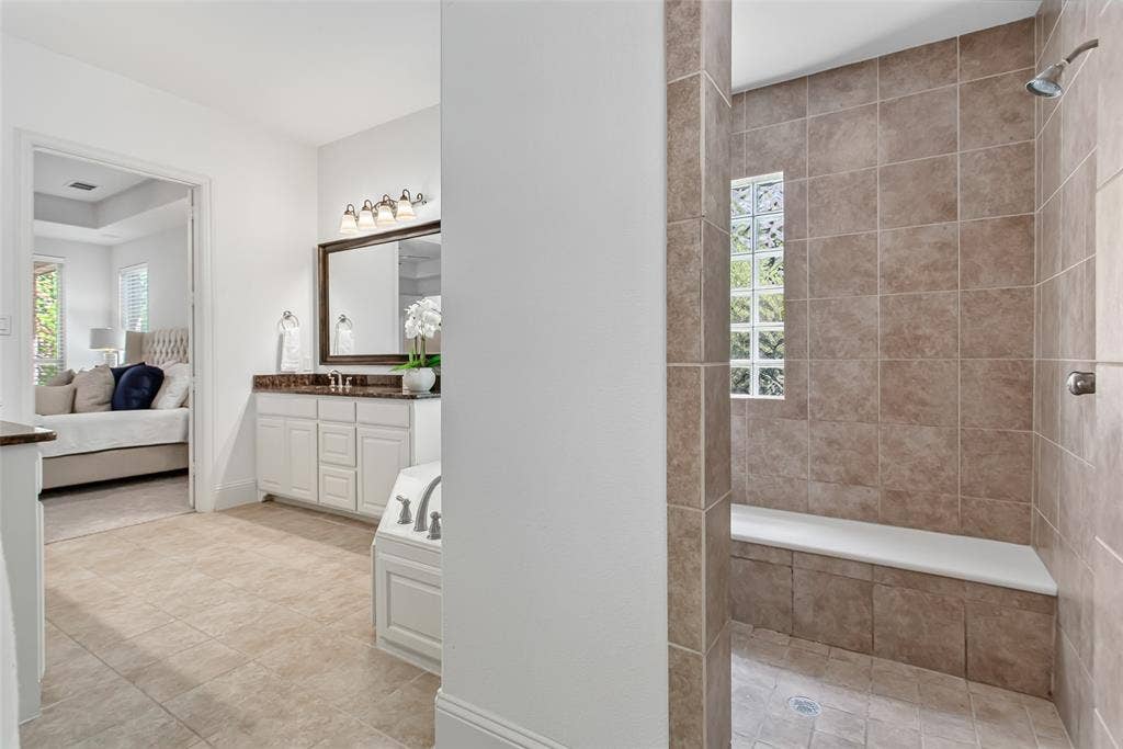 Tiled walk-in shower with a built-in bench and glass block window