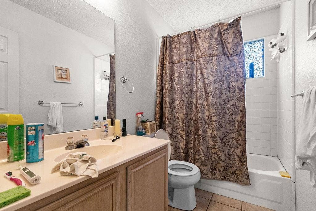 926 Wintercrest Court, Arlington, TX 76017 Vanity with integrated sink, full-width mirror, and a built-in bathtub with white tile surround