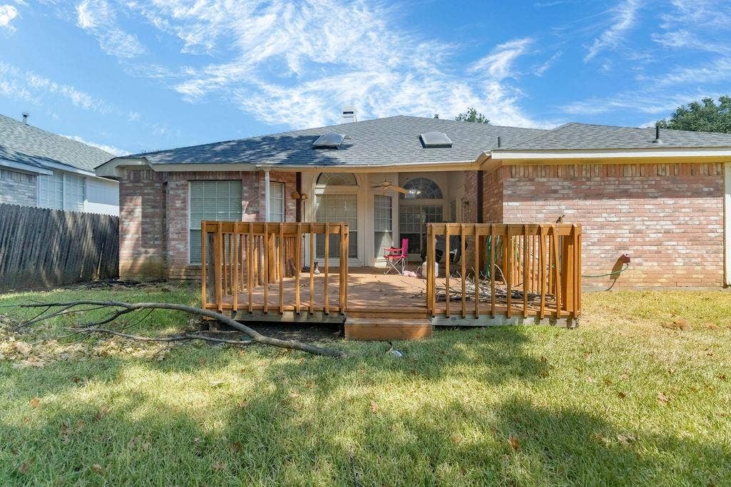 926 Wintercrest Court, Arlington, TX 76017 Brick exterior featuring a wood deck and a shingled roof with skylights