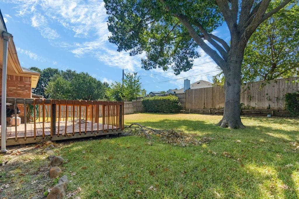 926 Wintercrest Court, Arlington, TX 76017 Expansive backyard featuring a wood deck, manicured lawn, and mature trees