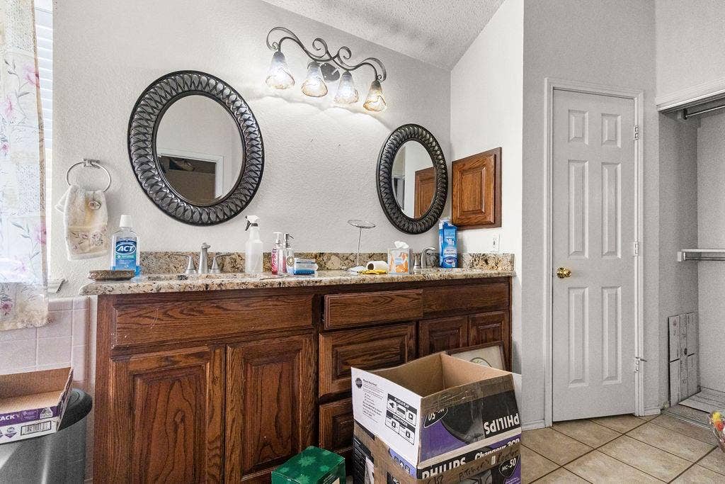 926 Wintercrest Court, Arlington, TX 76017 Double vanity with wood cabinetry, granite-style countertop, and integrated sinks