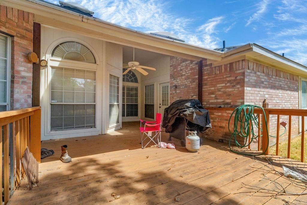 926 Wintercrest Court, Arlington, TX 76017 Expansive wood-finish deck with brick exterior, covered patio, arched window, and ceiling fan